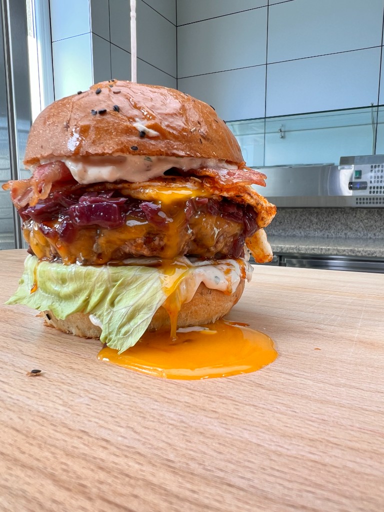 Burger so šťavnatým žĺtkom a roztaveným syrom na doske — Alcatraz Burger
